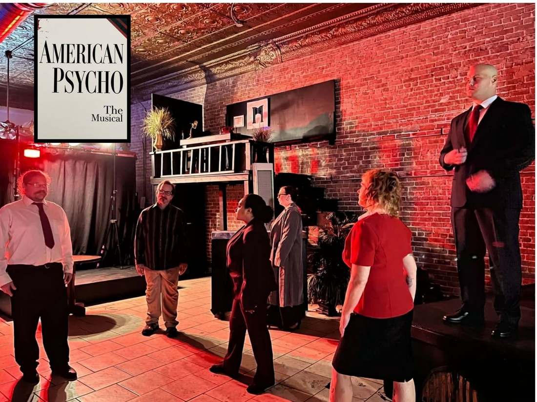 The American Psycho company performing beneath red stage lights