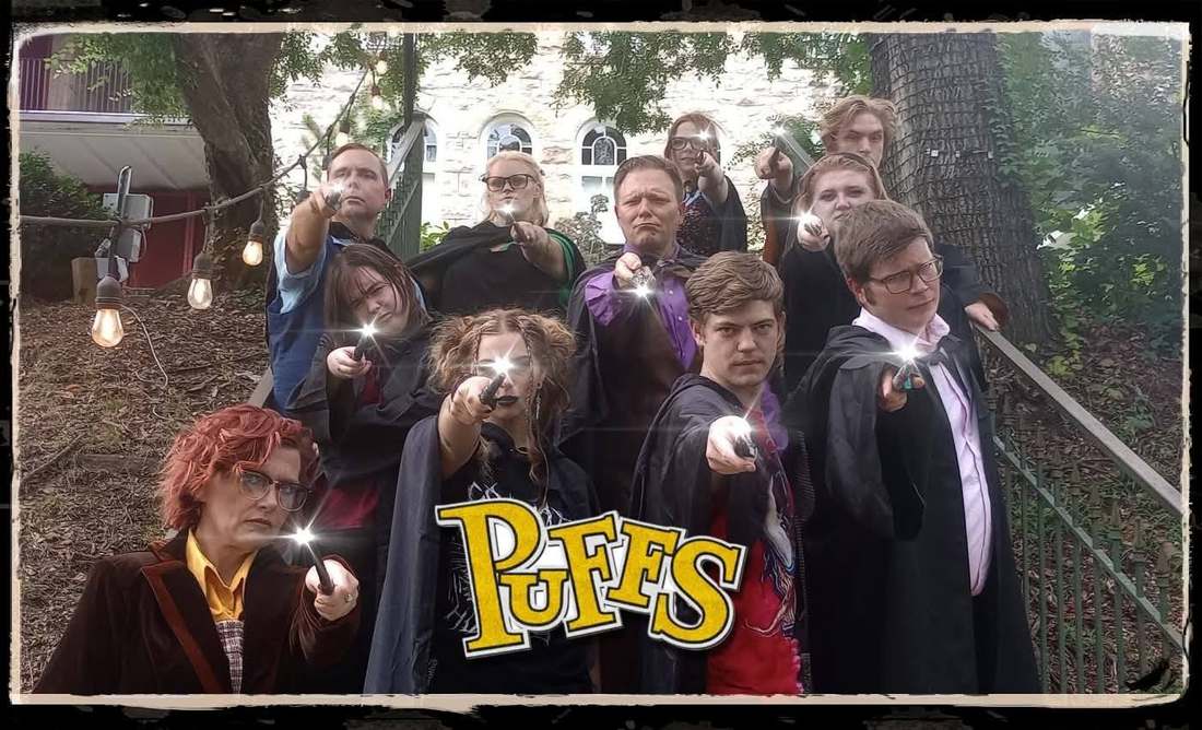 The Puffs company posing outdoors together with illuminated wands