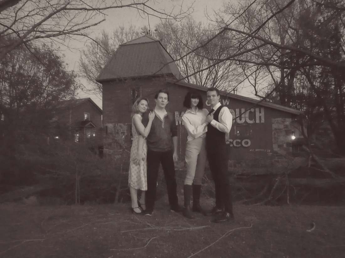 Four Bonnie and Clyde cast members posing outside a historic house