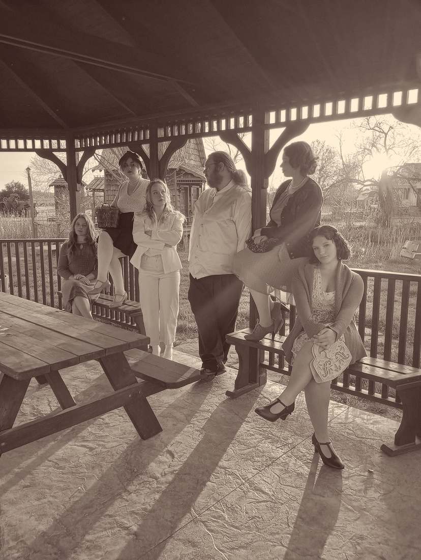 Six cast members gathered in a gazebo at sunset (sepia)