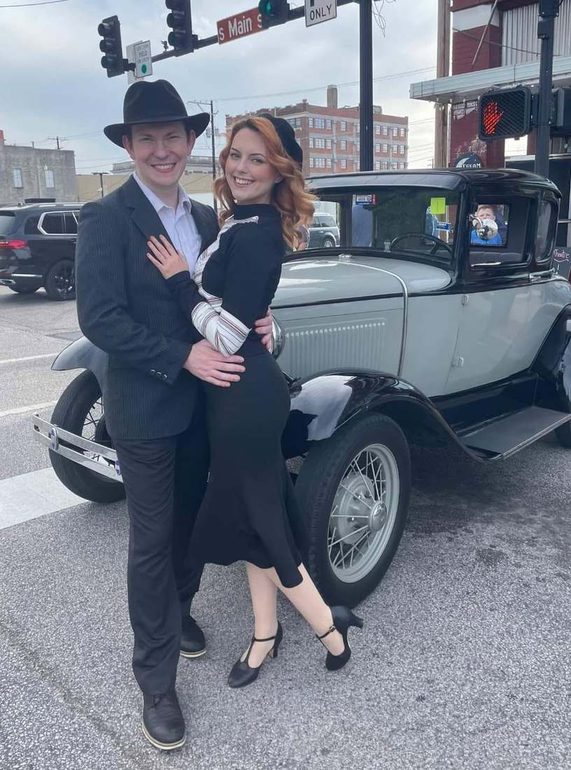 Bonnie and Clyde embracing in front of the vintage Ford Model A on South Main Street