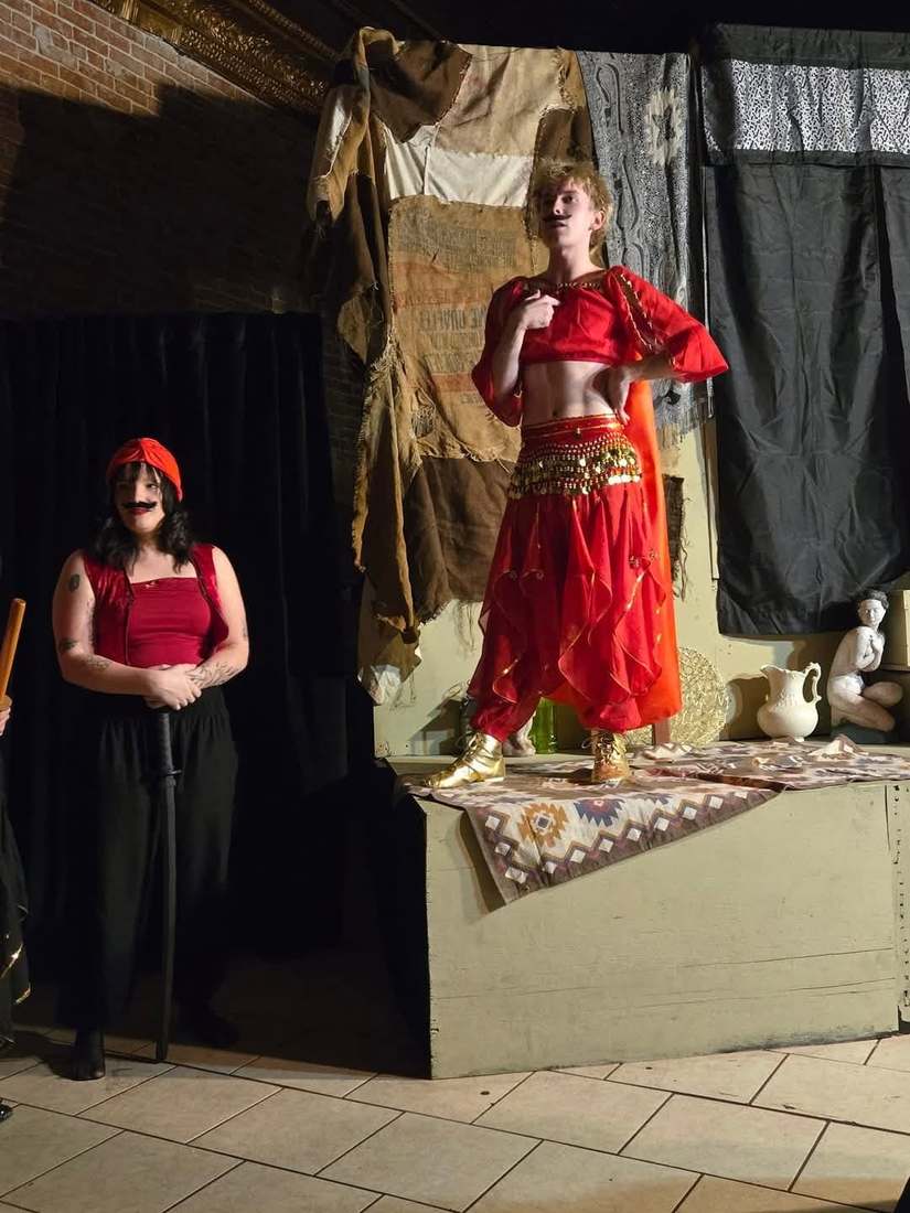 A dancer in red strikes a pose atop the platform in Twisted