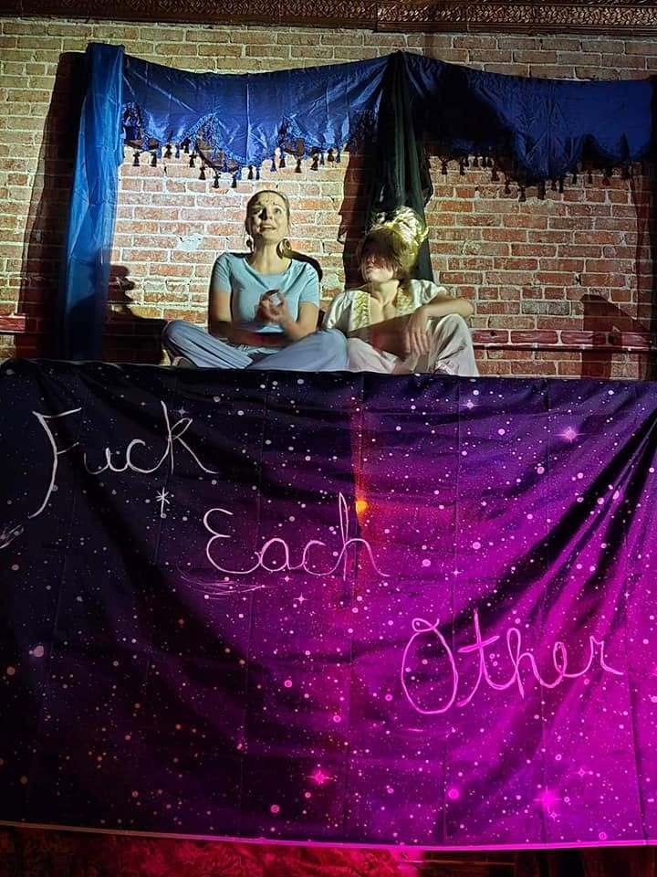 Two cast members peek over the starry finale banner, painted with the show's cheeky send-off message