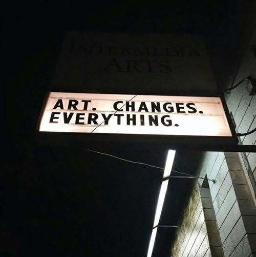 A lit marquee sign at night reading “Art. Changes. Everything.”